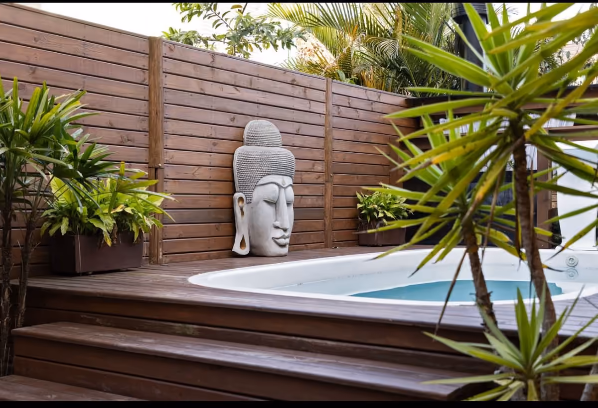 Hidromassagem no deck de madeira da Pousada Maria Eduarda, na Guarda do Embaú, com estátua de Buda e plantas