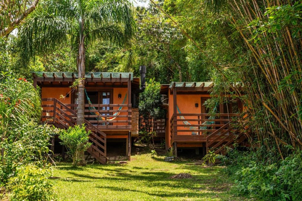 Área externa com redes e natureza na Coração da Terra Praia do Rosa