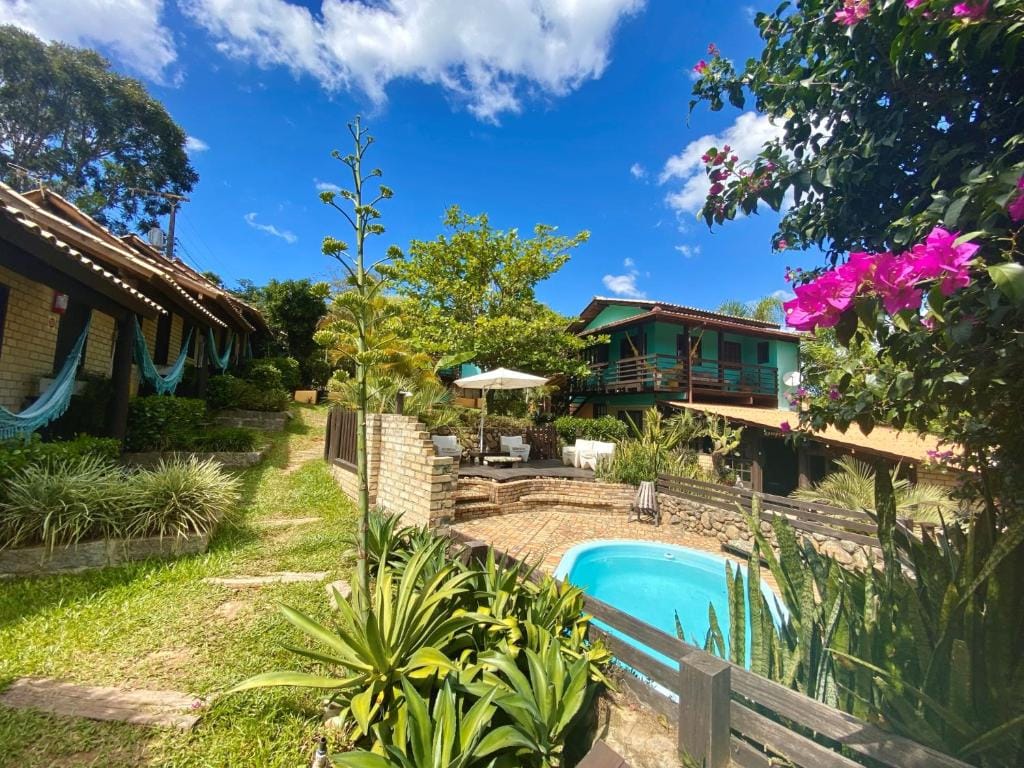 Área externa com piscina e jardim do Haleakala Hostel & Pousada na Praia do Rosa