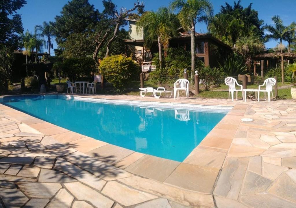 Piscina rodeada por natureza na pousada